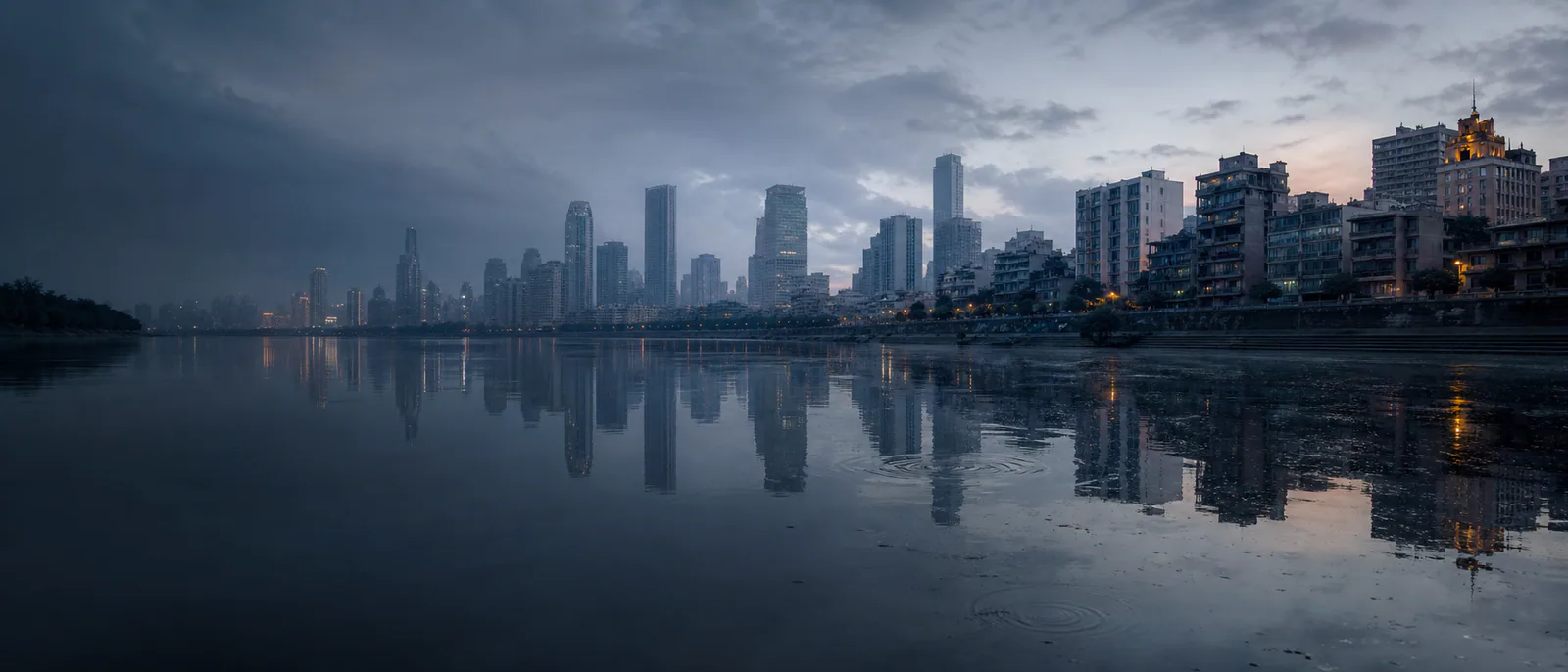 雨后城市在黎明河面上逐渐显形，倒置夜景被第一圈风纹打散。
